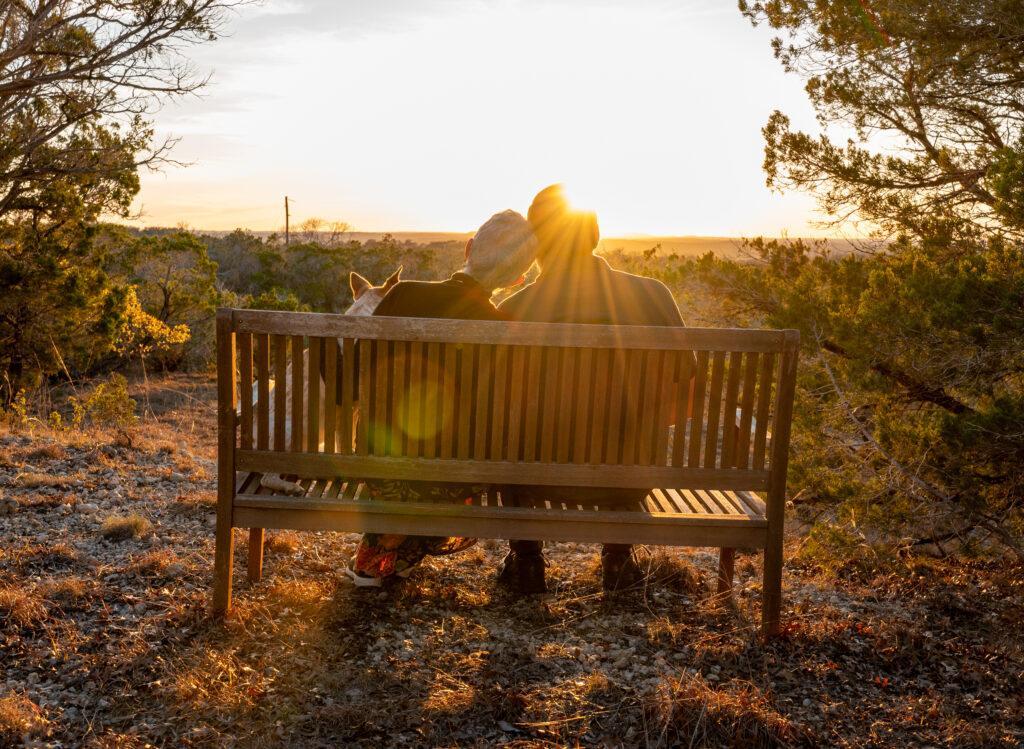 An LGBT engagement session sitting on a bench at sunset